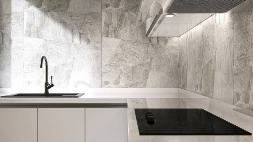 A contemporary kitchen countertop with an integrated induction cooktop and a minimalist design. - types of kitchen splashbacks
