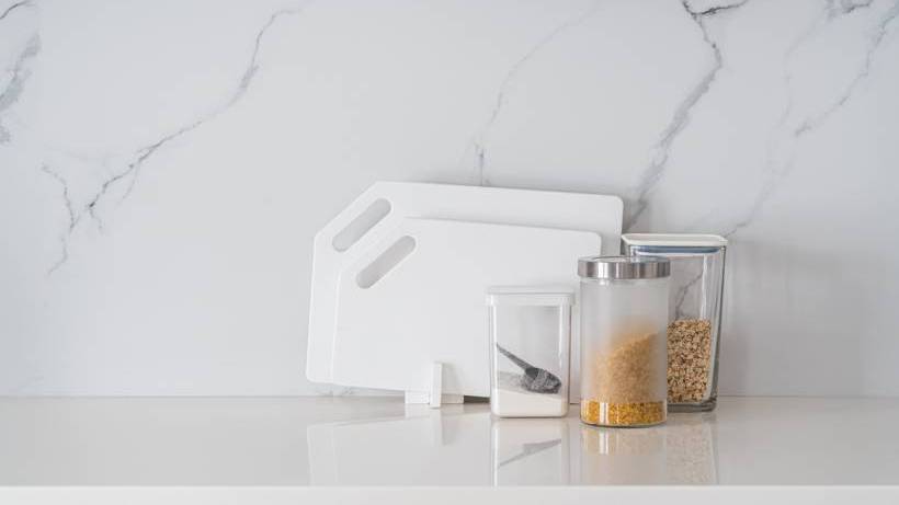 A clean, modern kitchen bench with a white marble-patterned acrylic splashback. - kitchen splashbacks type