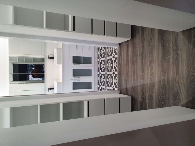 Elegant built-in cabinetry with white storage units and modern design, complemented by wood-look flooring and patterned tiles in a home interior